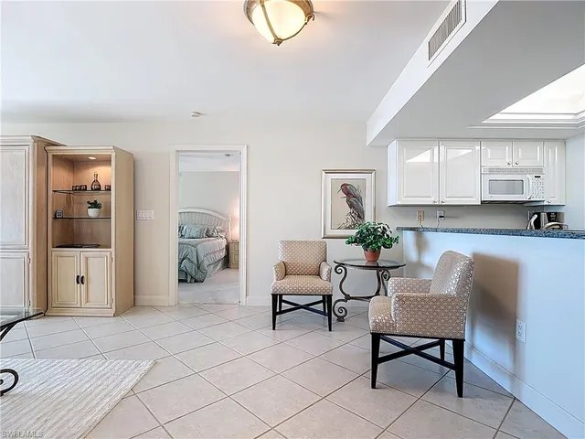 a living room with furniture a window and a potted plant