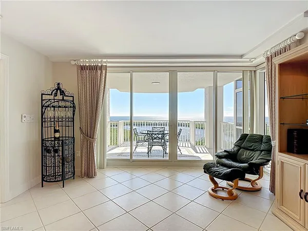 a living room with furniture and floor to ceiling windows