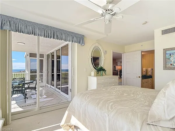 a spacious bedroom with a large bed and a chandelier