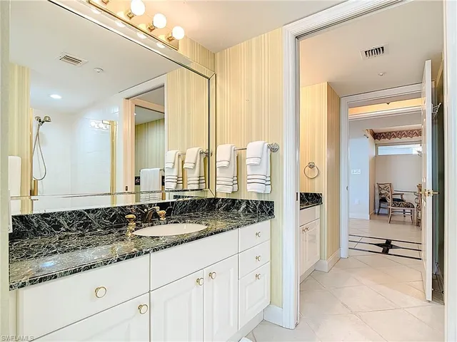 a bathroom with a granite countertop sink and a mirror
