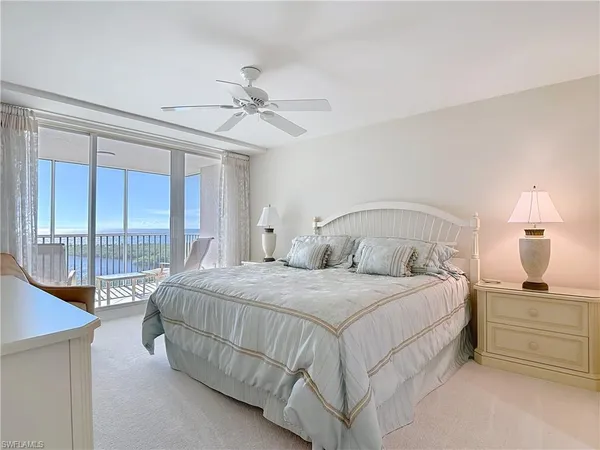 a bedroom with a bed and a large window