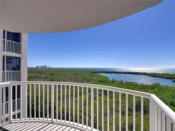 a view of a balcony with wooden floor & fence