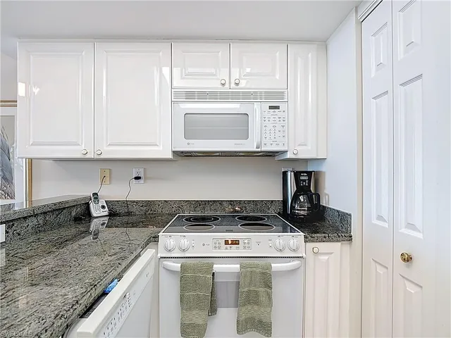 a kitchen with stainless steel appliances granite countertop a stove and a microwave