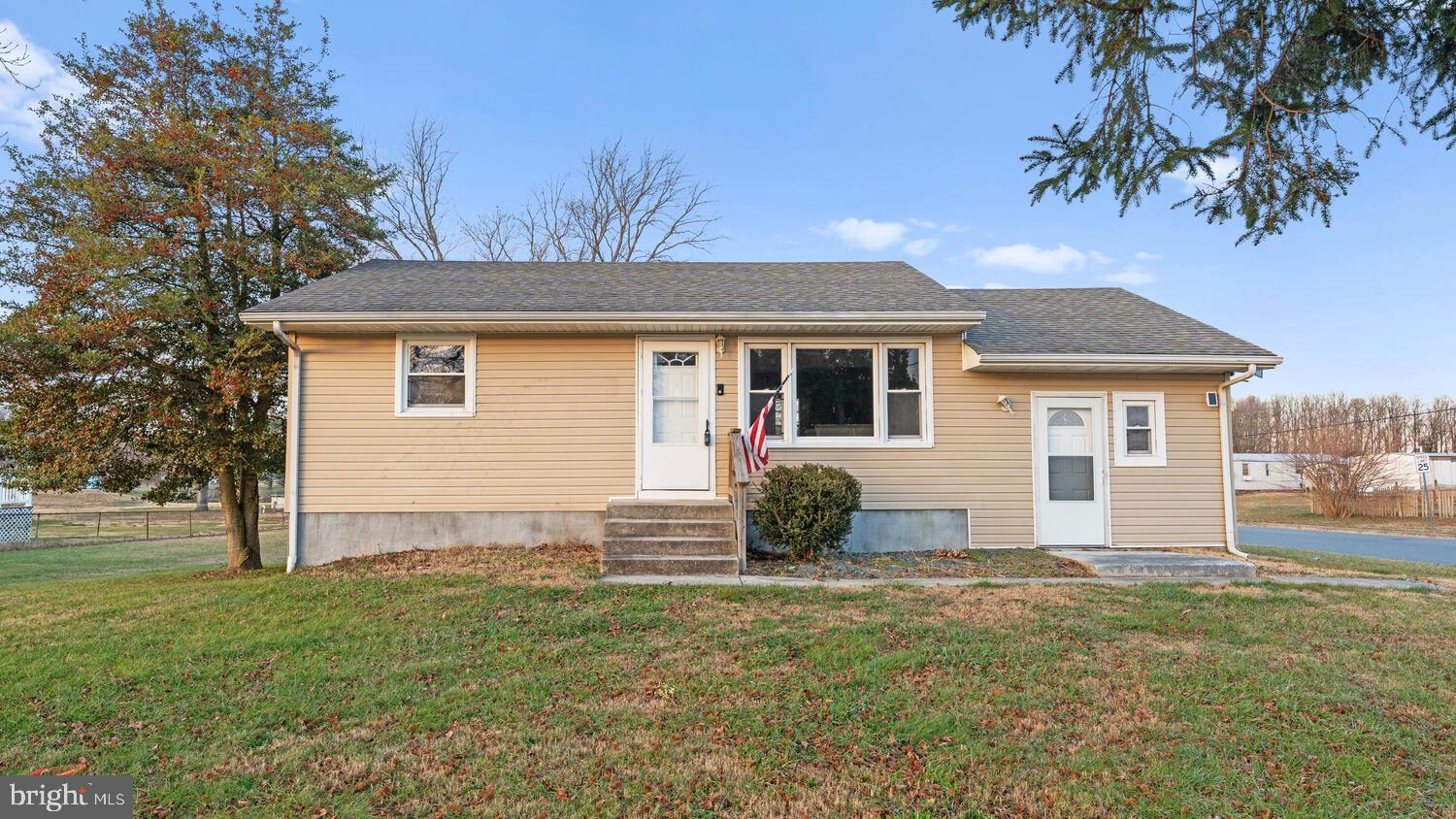 a front view of house with yard and trees around