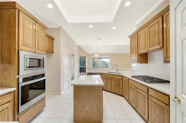 a kitchen with stainless steel appliances granite countertop a sink and cabinets