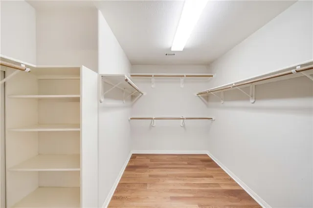 a view of walk in closet with empty racks