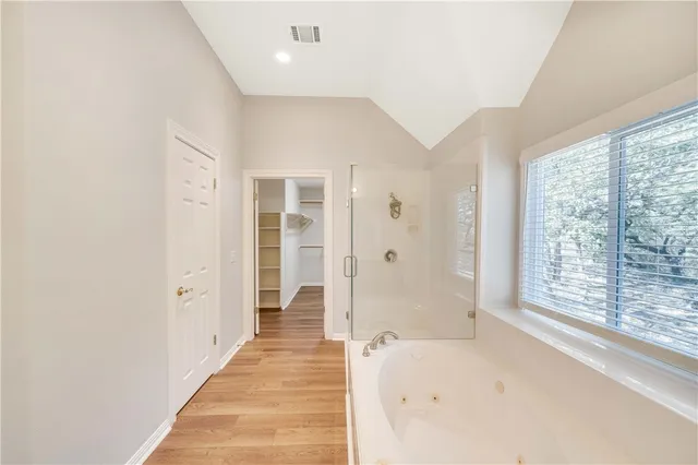 a view of a hallway with wooden floor and windows