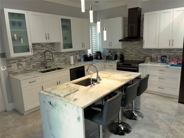 a kitchen with a table chairs sink and cabinets