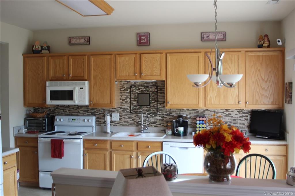 7539 Bluff Point Lane Denver, NC 28037 - Photo 15 of 30 a kitchen with stainless steel appliances kitchen island granite countertop a sink dishwasher a microwave oven and a dining table with wooden floor