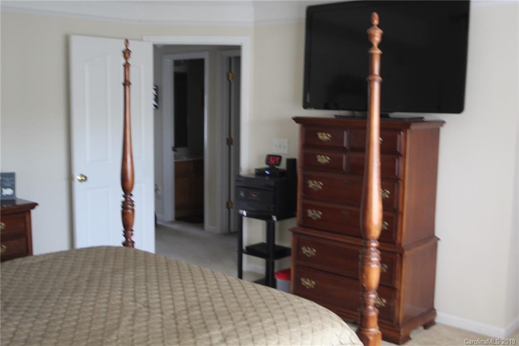 7539 Bluff Point Lane Denver, NC 28037 - Photo 20 of 30 a bedroom with a bed and a television on desk