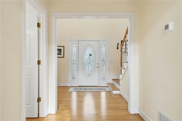 a view of a bathroom with wooden floor and a glass door