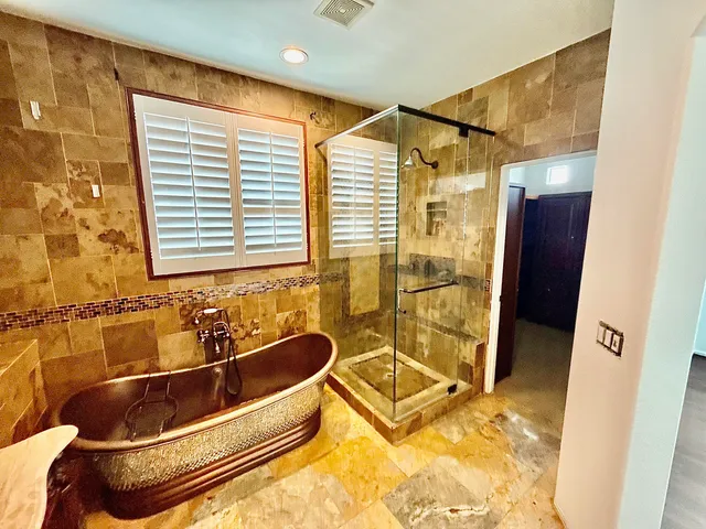a bathroom with a tub a sink and a shower