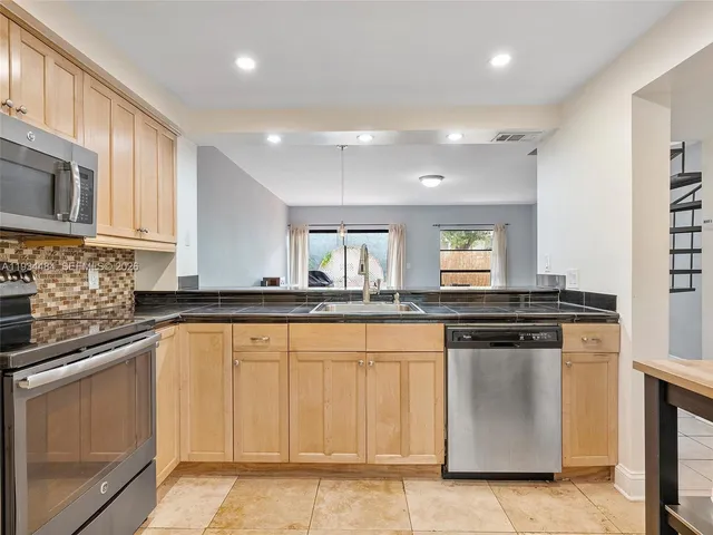 a kitchen with granite countertop white cabinets and a sink