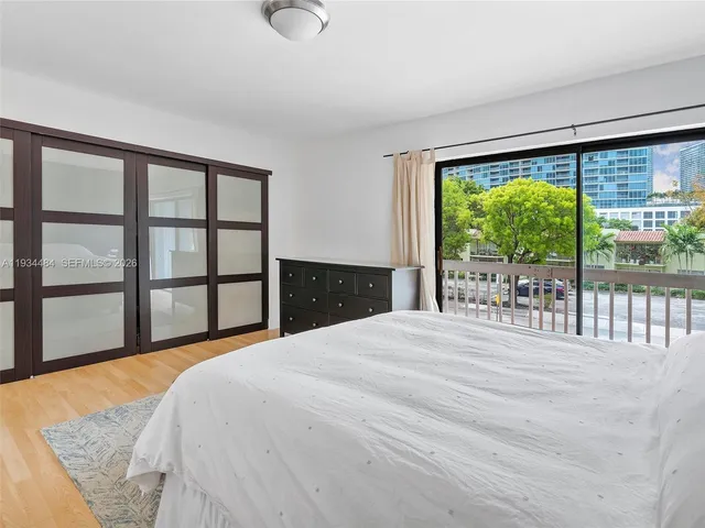 a bedroom with a bed and a large window with outer view