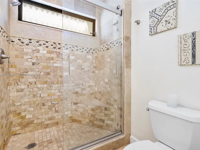 a bathroom with a toilet and a shower