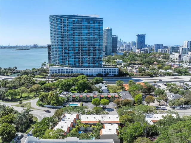 an aerial view of a residential houses with outdoor space and lake view