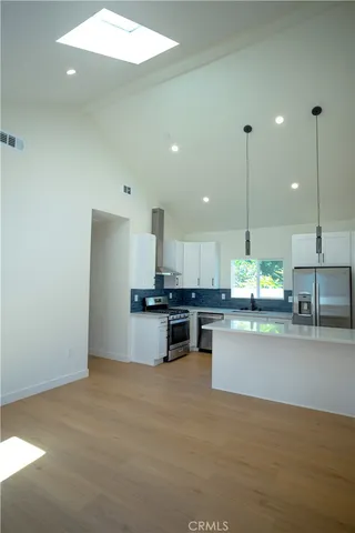 a kitchen with kitchen island a stove a counter top space a sink and a fireplace