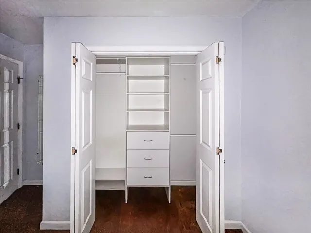 a view of walk in closet with empty racks