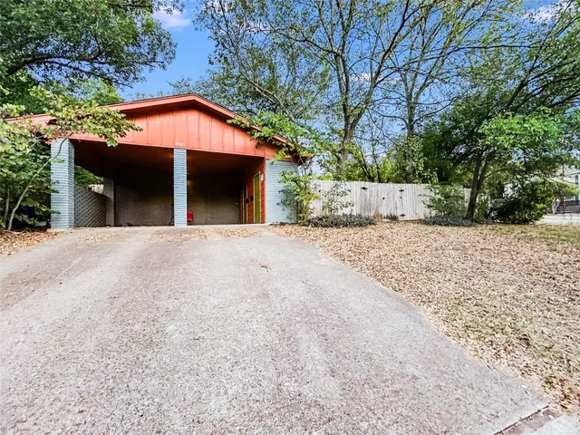 a view of a house with a yard and a large tree