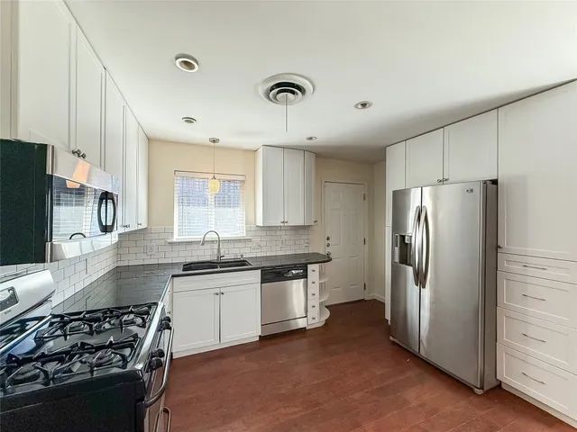 a kitchen with stainless steel appliances granite countertop a stove a refrigerator and a sink