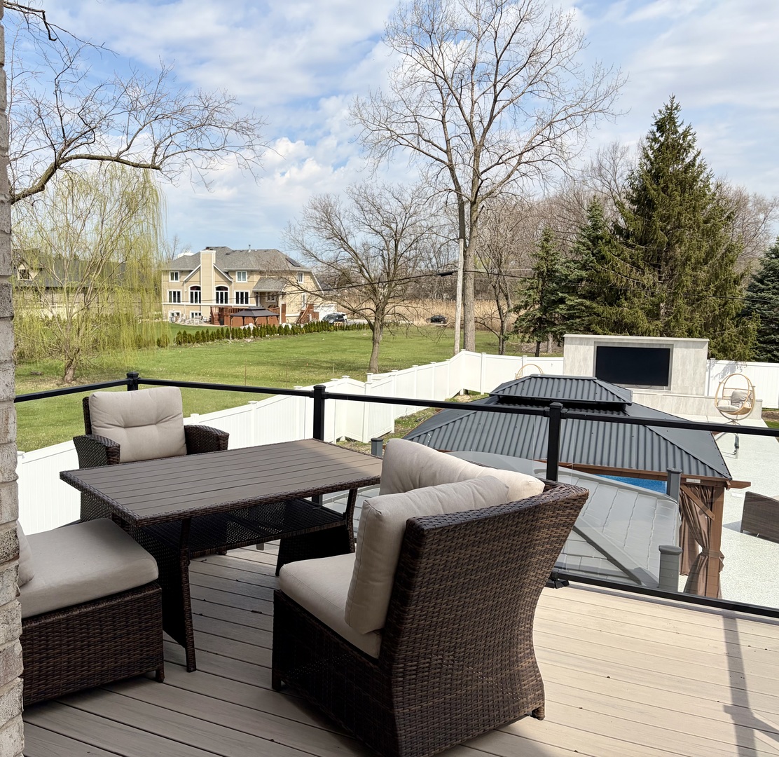 7381 South Madison Street Burr Ridge, IL 60527 - Photo 29 of 30 a view of a patio with couches table and chairs under an umbrella with large trees