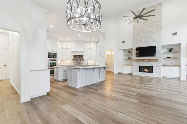 a view of kitchen with microwave a stove and white cabinets