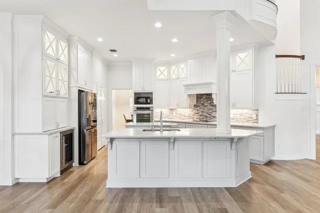 a kitchen with stainless steel appliances kitchen island granite countertop a refrigerator and a sink