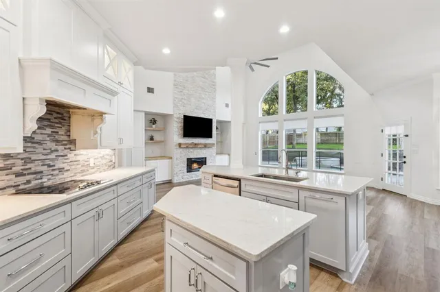 a view of a kitchen with stainless steel appliances granite countertop a sink and a stove