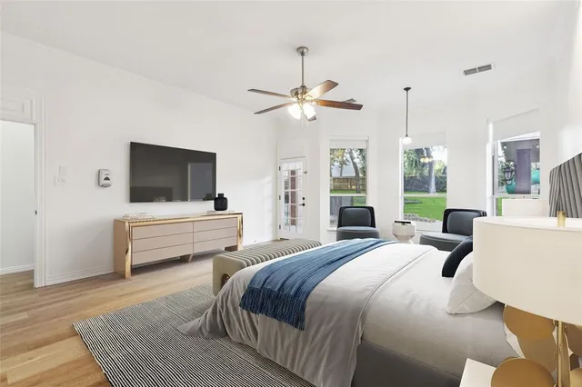 a bedroom with a bed a window and a flat screen tv