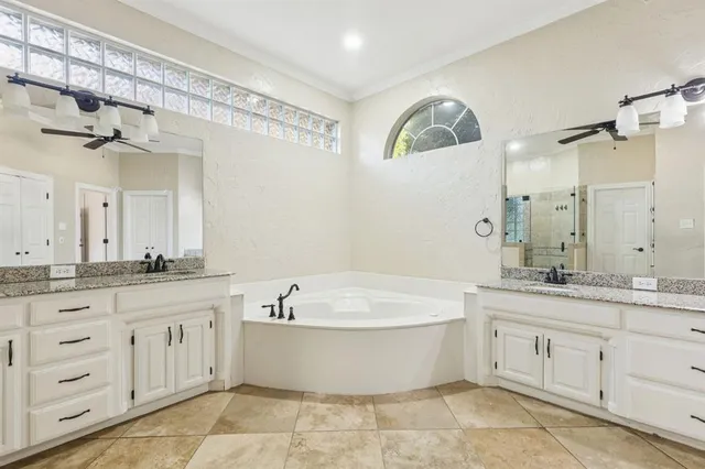 a bathroom with a granite countertop bathtub sink vanity and mirror