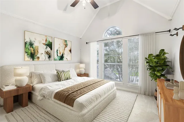 a bedroom with a large bed and a potted plant