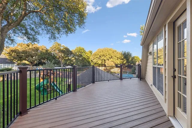a view of a balcony with wooden floor and fence