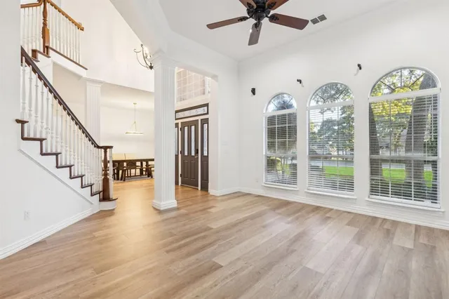 a view of an entryway with wooden floor windows and a chandelier