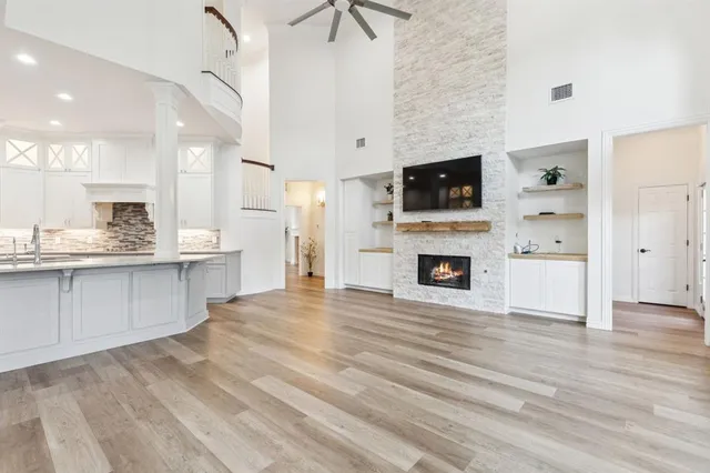 a view of kitchen with kitchen island wooden floor and stainless steel appliances