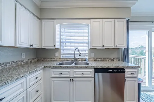 a kitchen with stainless steel appliances granite countertop a sink and a white cabinets