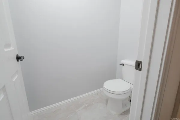 a white toilet sitting next to a shower