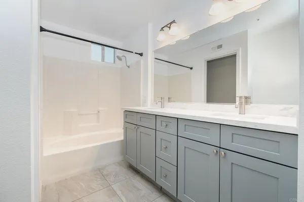 a bathroom with a tub sink and mirror
