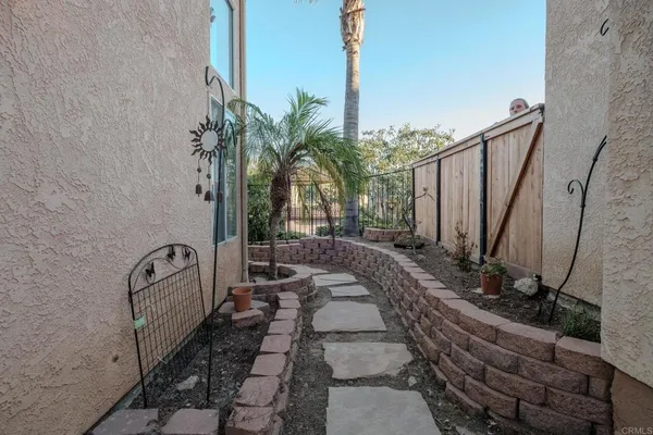 a view of a backyard with potted plants and large trees