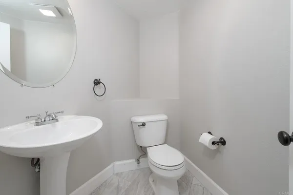 a bathroom with a toilet a sink and mirror
