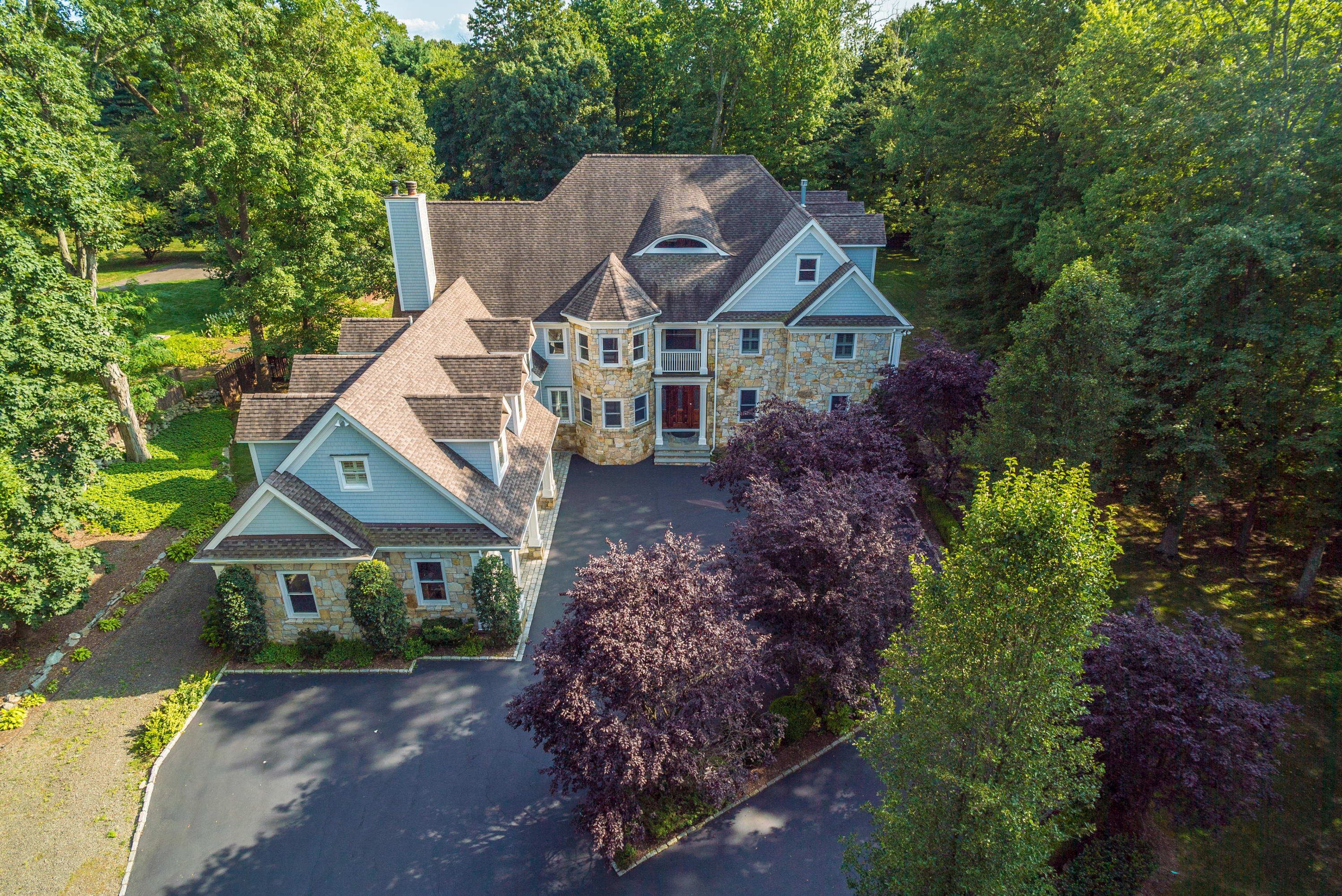 a view of a house with a yard and large trees