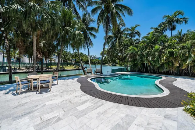 a view of a house with swimming pool and next to a yard