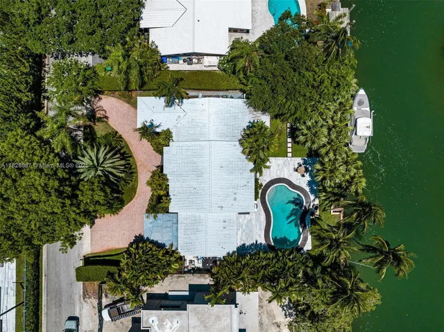 an aerial view of a house with a yard lake swimming pool outdoor seating and yard