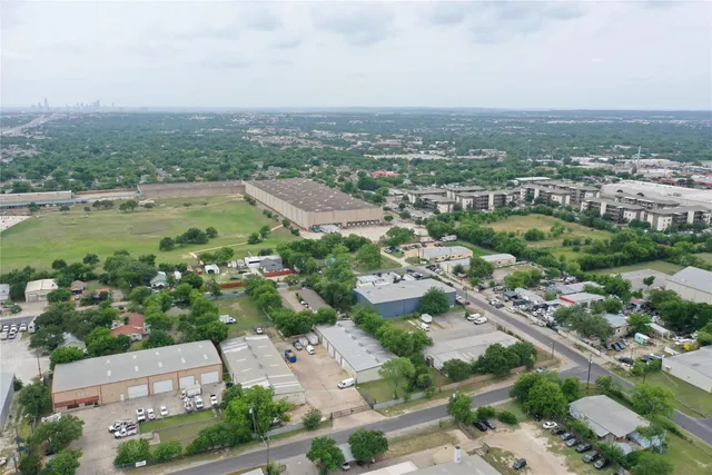 an aerial view of a city with lots of residential buildings and mountain view in back