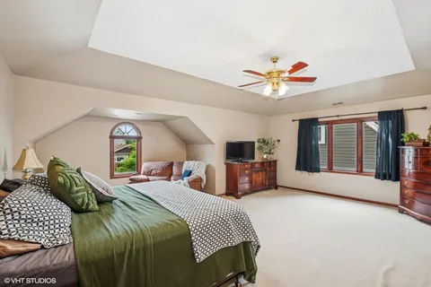 a spacious bedroom with a bed and ceiling fan