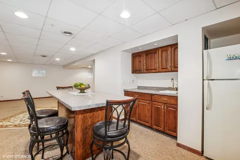 a kitchen with stainless steel appliances granite countertop a table chairs sink and cabinets