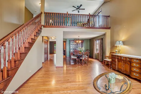 a view of an entryway wooden floor and dining room