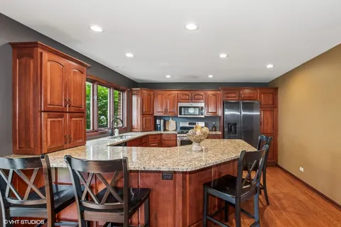a kitchen with granite countertop kitchen island stainless steel appliances a table and chairs
