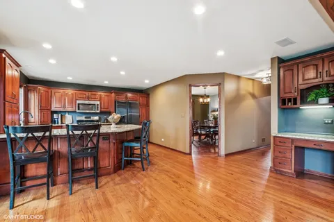 a view of a living room a kitchen island with furniture and wooden floor