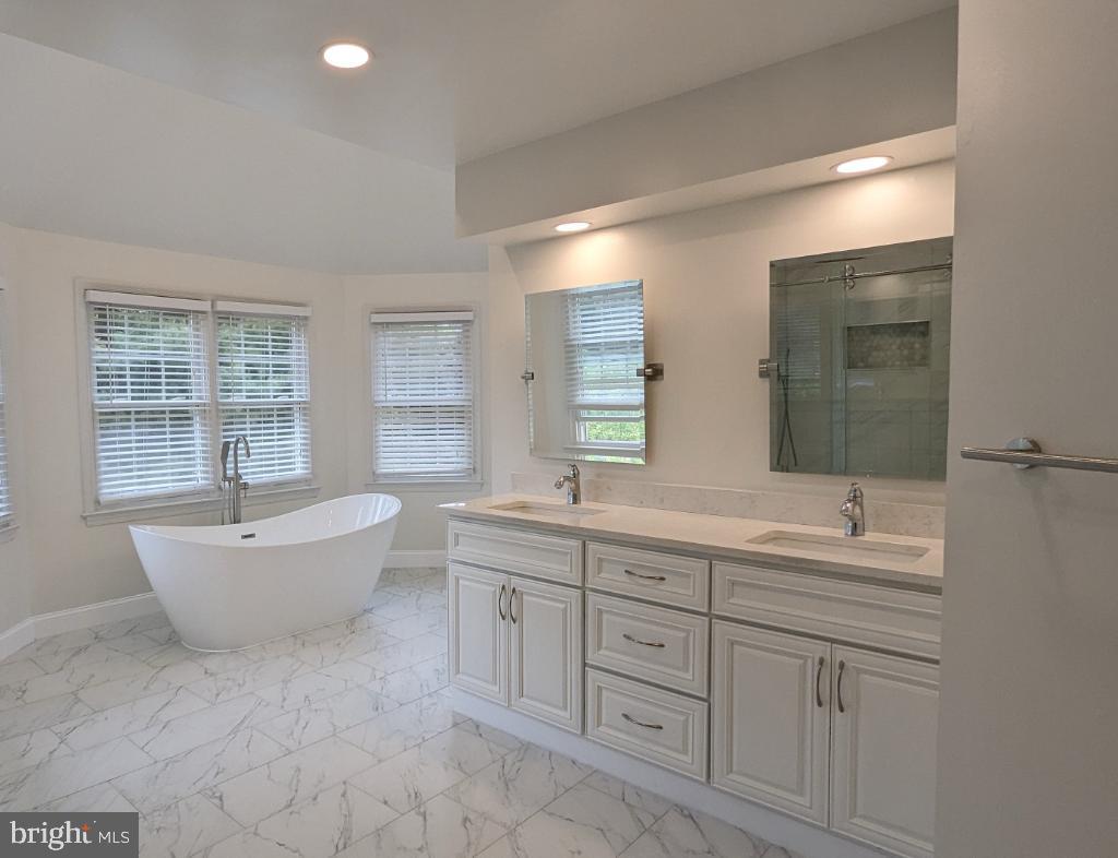 9706 Middleton Ridge Road Vienna, VA 22182 - Photo 14 of 17 a bathroom with a double vanity sink a bathtub and window