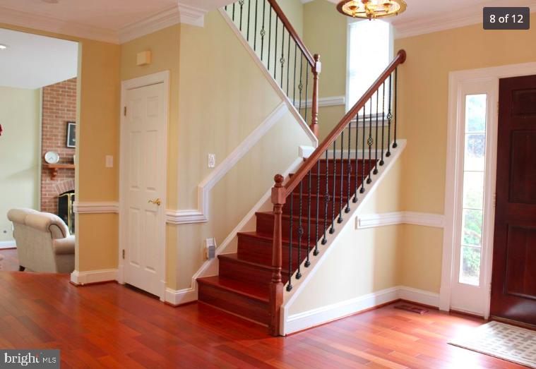 9706 Middleton Ridge Road Vienna, VA 22182 - Photo 2 of 17 a view of staircase with wooden floor and a chandelier